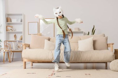 Kedi maskeli kız eve atlıyor.