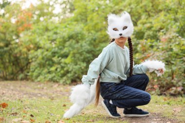 Kedi maskeli dörtlü kız parkta oturuyor.