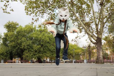 Kedi maskeli dörtlü kız parkta zıplıyor.