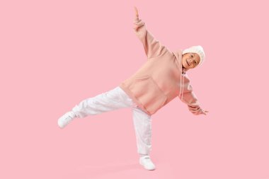 Beyaz örgü şapkalı şirin Asyalı çocuk pembe arka planda.