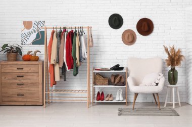 Modern wardrobe with stylish winter clothes and accessories