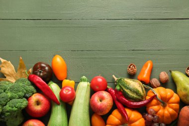 Yeşil ahşap arka planda meyveleri olan farklı taze sebzeler. Hasat festivali