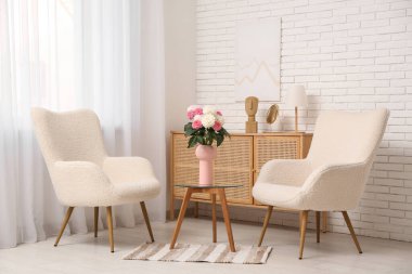 Oturma odasındaki masada çok güzel yıldız çiçekleri olan vazo.