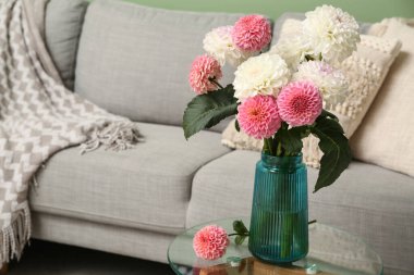 Oturma odasındaki masada çok güzel yıldız çiçekleri olan vazo.