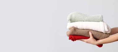 Gri arkaplan üzerinde kalın giysiler ve metin için yer olan kadın elleri