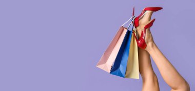 Kırmızı topuklu ayakkabılı kadınların ve eflatun arkaplanlı alışveriş torbalarıyla mesajlaşmak için yeri olan kadınların.