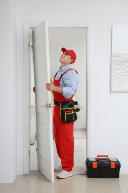 Erkek işçi eve kapı kuruyor.