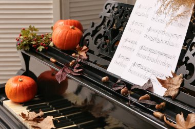 Piyano, balkabağı ve sonbahar yapraklarıyla süslenmiş. Yakın çekim.