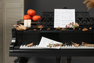 Sonbahar süslemeleri ve notaları olan piyano, yakın plan.