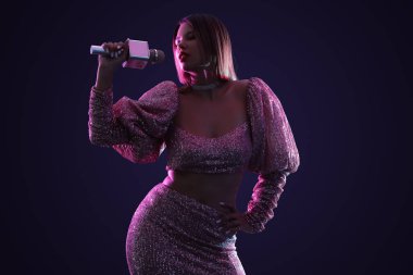 Koyu arka planda mikrofon ile güzel kadın şarkıcı