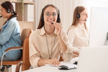 Ofiste çalışan kulaklıklı bayan teknik destek ajanı.