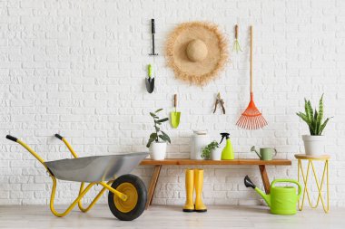 Yedek kulübesi, hasır şapkası ve bahçe aletleri olan atölyenin içi