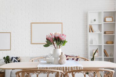 Yemek odasında protea çiçekleri olan masa ayarı