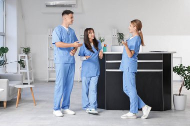 Kliniğin resepsiyonunda stajyerler konuşuyor.