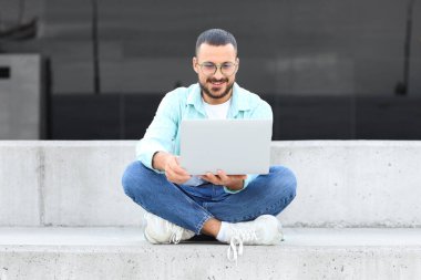 genç adam açık havada dizüstü kullanarak