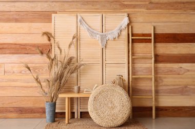 Bankta, puf ve katlanmış ekranlı kitapların olduğu odanın içi