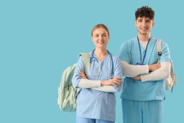 Mavi arka planda sırt çantalı tıp öğrencileri