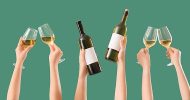 Bir sürü kadın eli yeşil arka planda bardak ve şarap şişeleri tutuyor. 