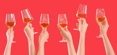 Kırmızı arka planda şarap kadehleri tutan birçok kadın eli var. 