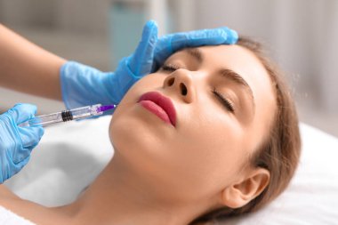 Genç bir kadın güzellik salonunda doldurma iğnesi yaptırıyor.