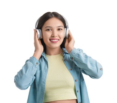 Kulaklıklı genç Asyalı kadın beyaz arka planda müzik dinliyor.