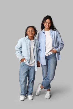 Gri arka planda kızı olan güzel, mutlu, Afro-Amerikan bir anne.