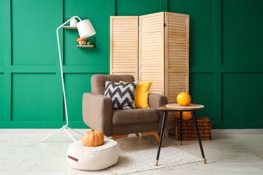 Sonbahar için dekore edilmiş modern oturma odası rahat koltuk, kahve masası ve katlanır ekran.