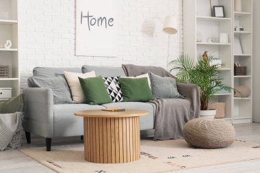 Oturma odasında kanepe, masa ve raf üniteleri var.