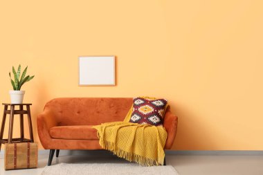 Kırmızı kanepede ekose ve boş çerçeveli oturma odasının içi.