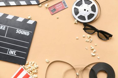 Sinema bileti, patlamış mısır ve bej arka planda film makaraları olan film alkışından yapılmış çerçeve