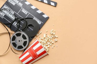 Patlamış mısır ve bej arka planda film makaraları olan film alkışları.