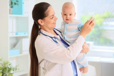 Klinikte küçük bebeği olan kadın bir çocuk doktoru.