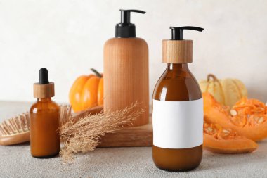 Beyaz arka planda kozmetik ürünleri ve balkabakları şişeleri