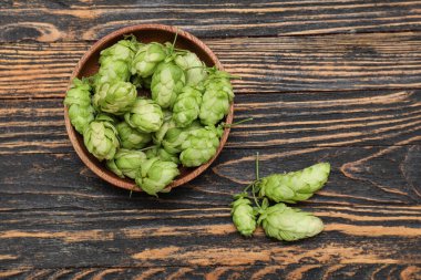 Siyah ahşap arka planda yeşil kozalaklar.