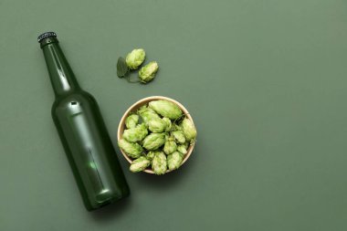 Zıpzıp külahlı kase ve yeşil arka planda bir şişe bira.