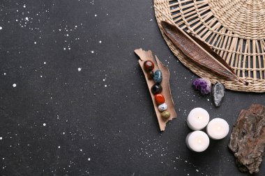 Koyu arkaplanda çakra taşları, tütsü ve mumlar.