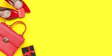 Kadın aksesuarları ve hediye paketi sarı arka planda mesaj için yer var. Kara Cuma indirimi