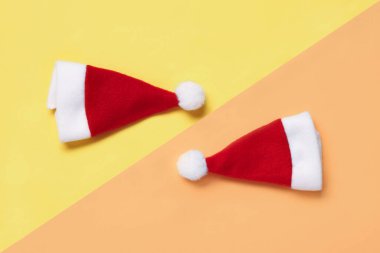 Renkli arka planda Noel Baba şapkaları