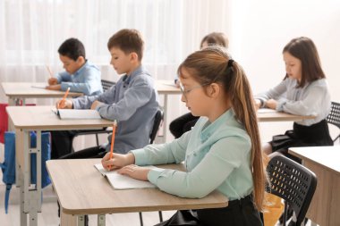 Sınıfta ders sırasında egzersiz yapan bir grup çocuk.