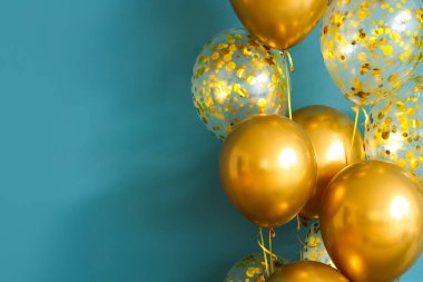 Mavi duvarın yanındaki altın hava balonları