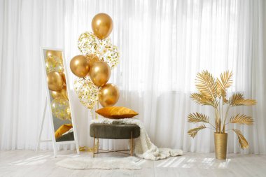 Modern oturma odasının penceresinin yanında yer aynası, puf ve hava balonları.