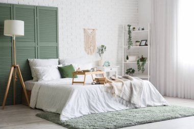 Yatak odasının içinde kahvaltı ve yatağın üstünde kitaplar.