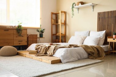 Şık bir yatak odası, yatakta kahvaltı ve kitaplar.