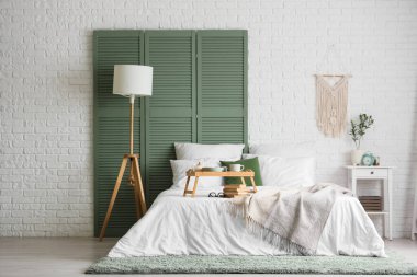 Yatak odasının içinde kahvaltı ve yatağın üstünde kitaplar.