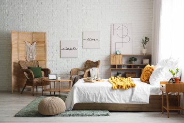 Yatak odasının içinde koltuklar, kahvaltı ve yatağın üstünde kitaplar var.