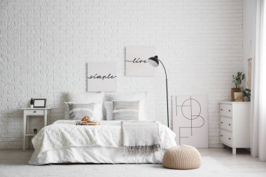 Yatak odasının içinde lamba, kahvaltı ve yatağın üstünde kitaplar var.