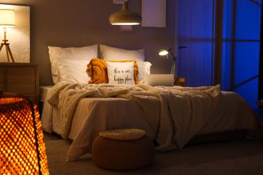 Geceleri yatağında parlak lambalar ve dizüstü bilgisayarı olan karanlık yatak odasının içinde.