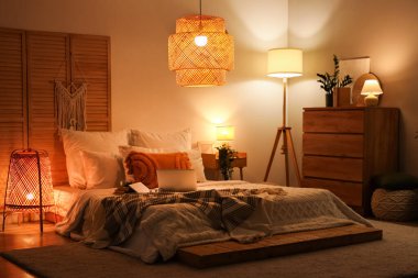 Parlayan lambalar, dizüstü bilgisayarlar ve kitaplarla dolu yatak odasının içi.