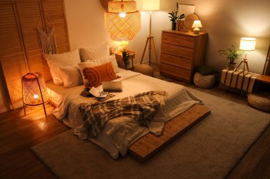 Parlayan lambalar, dizüstü bilgisayarlar ve kitaplarla dolu yatak odasının içi.