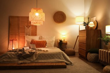 Parlayan lambalar, dizüstü bilgisayarlar ve kitaplarla dolu yatak odasının içi.